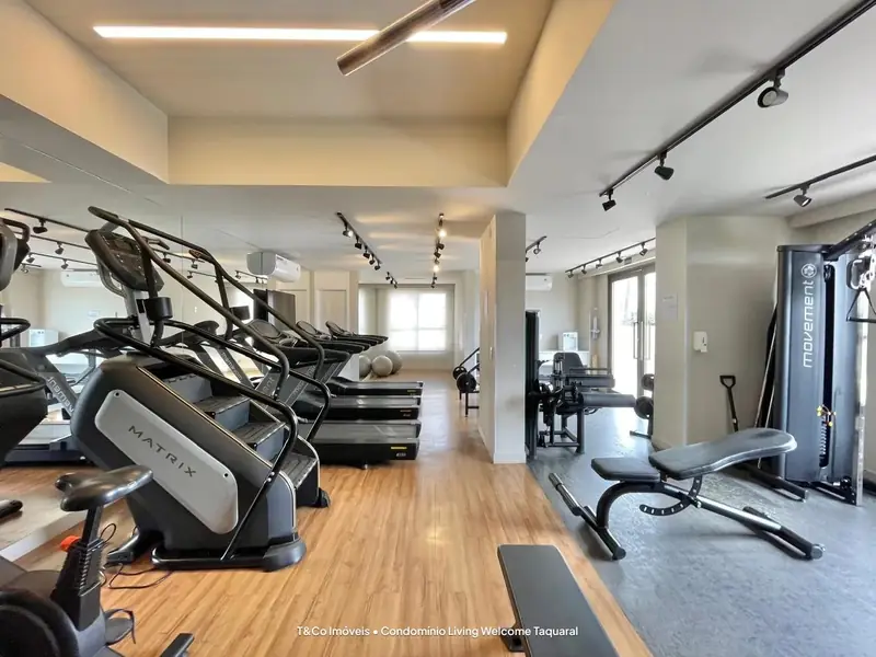 Academia interna do Living Welcome Taquaral com esteiras e aparelhos de musculação