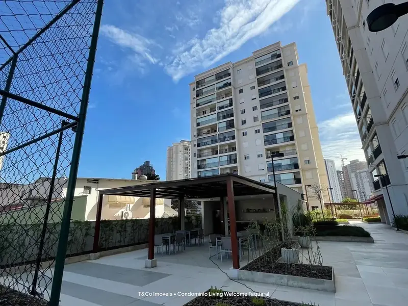 Área de convivência com pergolado e mesas no Living Welcome Taquaral