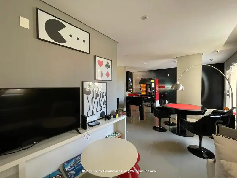 Espaço com TV e mesa de jogos no Living Welcome Taquaral